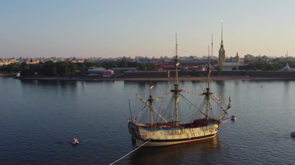 Stadtlandschaft aus der Luft am Morgen mit einer Replik der alten Fregatte Poltawa vor dem Hintergrund der Peter-und-Paul-Festung vor dem Urlaub der russischen Marine, Wasserfläche des Flusses Newa — Stockvideo