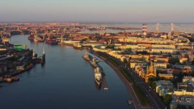 Gündoğumunda Rus Donanması 'nın bayramından önce Neva Nehri' nin sularında savaş gemilerinin bulunduğu havadan sabah manzarası arka planda tersane vinçleri, kablo destekli köprü, set.