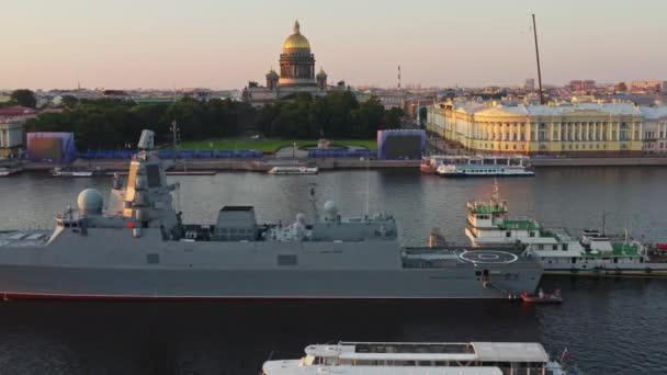 Légi reggeli városi táj hadihajókkal a Neva folyó vizein az orosz haditengerészet nyaralása előtt, tengeri erő, a legújabb cirkáló a látnivalók között, Isaac katedrális a háttérben — Stock videók