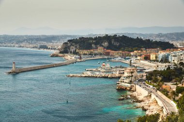 Güneşli bir günde Fransa 'nın Nice limanındaki feribot terminali birçok motorlu tekne ve lüks yatlar limana demirlemiş demirleme halatları muhteşem gök mavisi sularına, ünlü deniz kenarına ve deniz fenerine gidiyor.