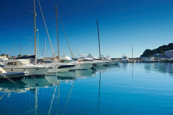 Mónaco, Montecarlo, muchos barcos a motor están amarrados en puerto en un día soleado, las cuerdas de amarre entran en el agua azul, las proas de los barcos a motor en una fila, barandillas de barcos — Foto de Stock