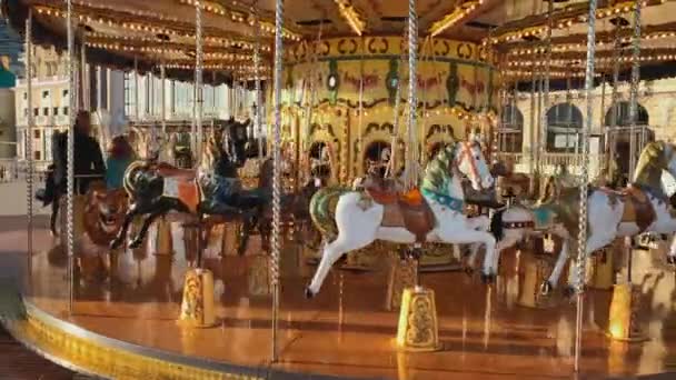 Monaco, Monte-Carlo, 25 December 2019: Children ride on the festive carousel operating at the Christmas festivities, parents watch the children, casino and hotel Paris in the background — Stock Video