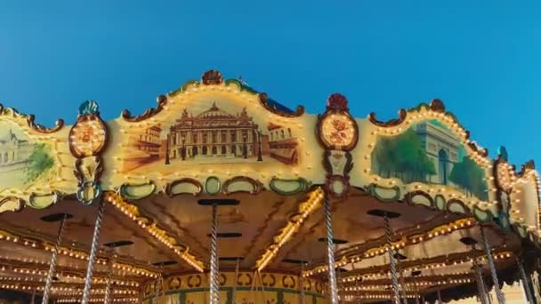 Mónaco, Montecarlo, 25 de diciembre de 2019: Adornos del carrusel festivo que opera en las festividades navideñas al atardecer, cielo azul claro sobre fondo — Vídeos de Stock