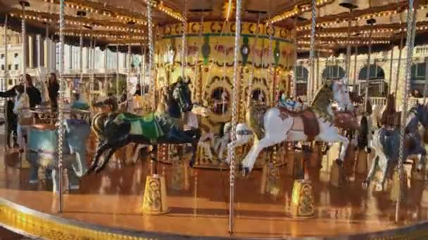 Monaco, Monte-Carlo, 25 December 2019: Children ride on the festive carousel operating at the Christmas festivities, parents watch the children, casino and hotel Paris in the background — Stock Video