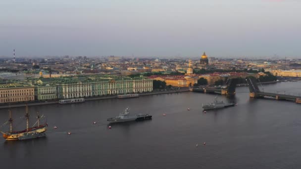 早朝にロシア海軍の休日の前に古代フリゲートPoltavaと現代の巡洋艦のレプリカの空中風景、ネヴァ川の水域、アイザック大聖堂、冬の宮殿 — ストック動画