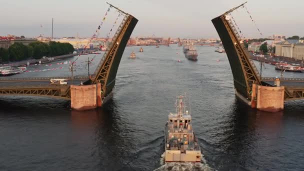 Воздушный ландшафт с военными кораблями в Неве перед праздником российского флота рано утром, военные корабли проходят под возведенным мостом, новейшие крейсера среди достопримечательностей, Дворцовый мост — стоковое видео