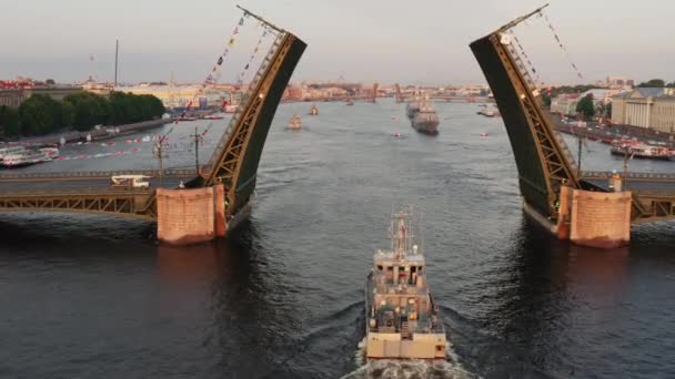 Flyglandskap med krigsfartyg i Neva floden före semestern i den ryska flottan tidigt på morgonen, krigsfartyg passerar under en upphöjd vindbrygga, de senaste kryssare bland landmärken, Palace Bridge — Stockvideo