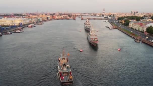 Flygfoto morgon stadslandskap med krigsfartyg i vattnen i Neva River före semestern i den ryska flottan, sjökraft, de senaste kryssare bland sevärdheterna, Isaac katedralen på en bakgrund — Stockvideo