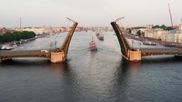 Flyglandskap med krigsfartyg i Neva floden före semestern i den ryska flottan tidigt på morgonen, krigsfartyg passerar under en upphöjd vindbrygga, de senaste kryssare bland landmärken, Palace Bridge — Stockvideo