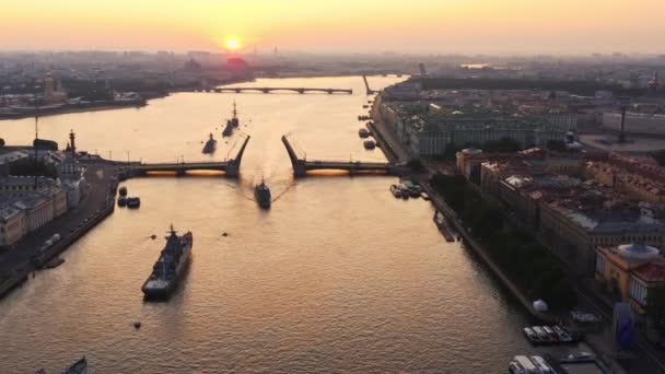 Légi táj hadihajókkal a Neva folyóban az orosz haditengerészet kora reggeli nyaralása előtt, hadihajók haladnak el egy emelt felvonóhíd alatt, a legújabb cirkáló a tájékozódási pontok között, Palota híd — Stock videók
