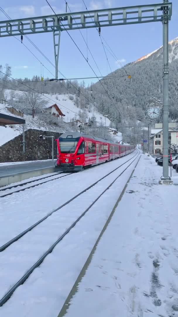 Ελβετία, Filisur, 12 Δεκεμβρίου 2019: Το περίφημο τρένο του κόκκινου παγετώνα αναχωρεί από το σιδηροδρομικό σταθμό, κοντά στο Landwasser Viaduct — Αρχείο Βίντεο