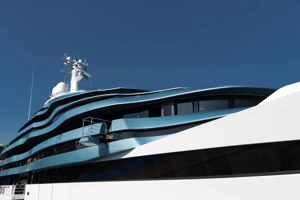 Bottom view of decks of huge yacht of blue color at sunny day, glossy board of the motor boat, sun reflection on glossy board, blue sky is on background — Stock Photo, Image