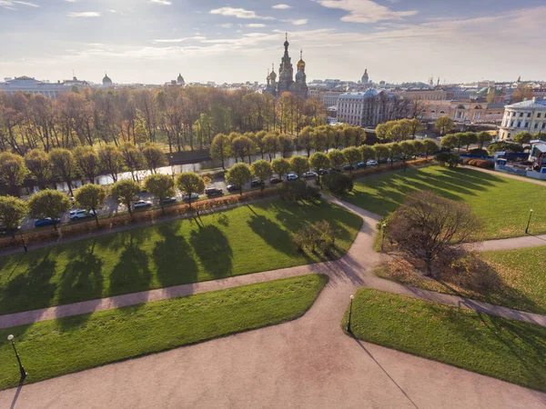 Russia, Saint-Petersburg, Aerial view of the church of the Saviour on Blood at sunset, golden domes, roofs of city, a panorama field of Mars, shadows of trees, autumn — Stock Photo, Image