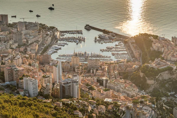 Vista aérea del Principado de Mónaco al amanecer, Monte Carlo, casco antiguo, punto de vista en La Turbie por la mañana, puerto Hercule, Palacio Príncipe, Montañas, Megayates, muchos barcos, reflejo del sol — Foto de Stock