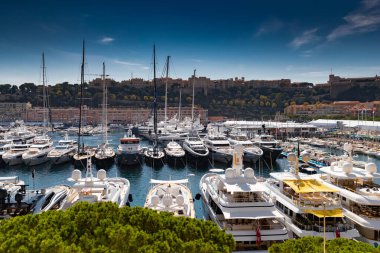 Güneşli bir günde Monaco Herkül Limanı 'nda bir sürü büyük yat vardır, Monte Carlo, arka planda bir sürü küçük tekne, motorlu tekne iç kısımları, megayacht serinleme bölgesi, parlak tahtalara yansıyan güneş yansımaları.