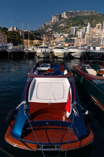 Una gran cantidad de barcos a motor en filas están en el puerto de Mónaco en el día soleado, Monte Carlo, la montaña está en el fondo, colorido interior del barco, están amarrados en el puerto deportivo, reflejo del sol en el tablero brillante — Foto de Stock
