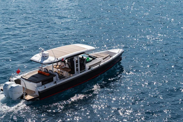 The large luxury boat on the background of blue water, port of Hercules in Monaco, sunny glare of the sun on the water, powerful boat, glossy surfaces shine in sunny weather — Stock Photo, Image