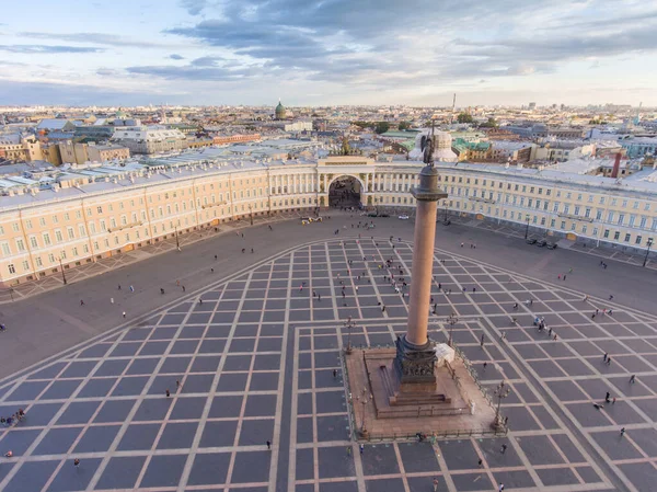 Luchtfoto van Palace Square en Alexander Column bij zonsondergang, een koepel van Kazanskiy kathedraal op de achtergrond, het Winterpaleis, wandelen een beetje mensen — Stockfoto