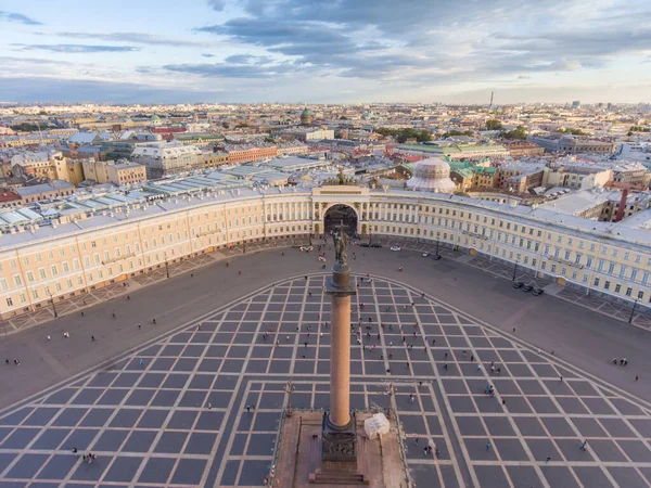 Vista aérea de la Plaza del Palacio y la Columna de Alejandro al atardecer, una cúpula de la Catedral de Kazanskiy en el fondo, el Palacio de Invierno, caminar un poco la gente — Foto de Stock