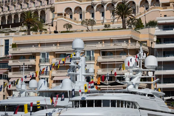Muchos yates enormes están en el puerto de Mónaco en el día soleado, Monte Carlo, la vivienda de bienes raíces está en el fondo, tablero brillante de la lancha a motor, megayates están amarrados en marin — Foto de Stock