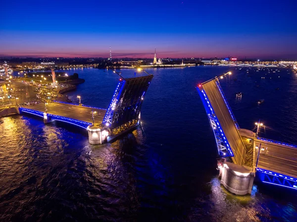 Lucht nacht landschap van festiviteiten op paleis dijk op brug tekening in St. Petersburg, Rusland, pittoreske nacht verlichting van bezienswaardigheden, veel plezier boten, veel mensen — Stockfoto