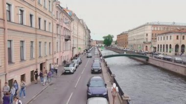 Rusya, St. Petersburg, 13 Haziran 2021: Bulutlu bir yaz gününde Griboyedov Kanalı üzerinde bir İHA uçuyor, insanlar toprak sette yürüyor ve köprülerde yürüyor, arabalar yavaş hareket ediyor ve trafikte duruyor