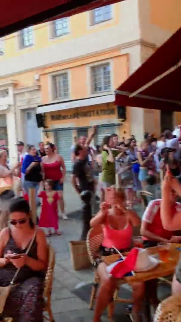 Frankreich, Nizza, 15. Juli 2018: Bei der Feier des WM-Sieges der Fußballmannschaft an einem klaren, sonnigen Sommertag tanzen Fans auf Cafétischen, die Menschen haben Spaß und machen Lärm — Stockvideo