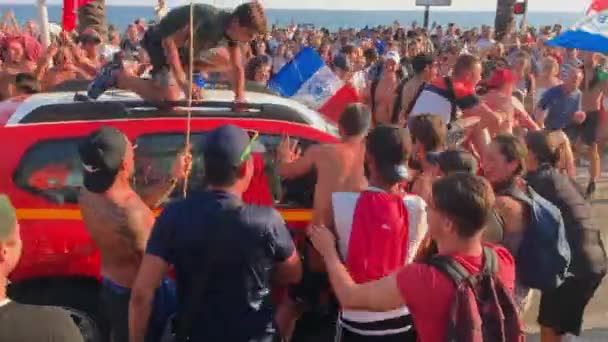 Francja, Nicea, 15 lipca 2018 r.: Świętowanie zwycięstwa drużyny piłkarskiej w Pucharze Świata w pogodny, słoneczny letni dzień, fani hałasują i utrudniają przejazd samochodów, flag Francji — Wideo stockowe