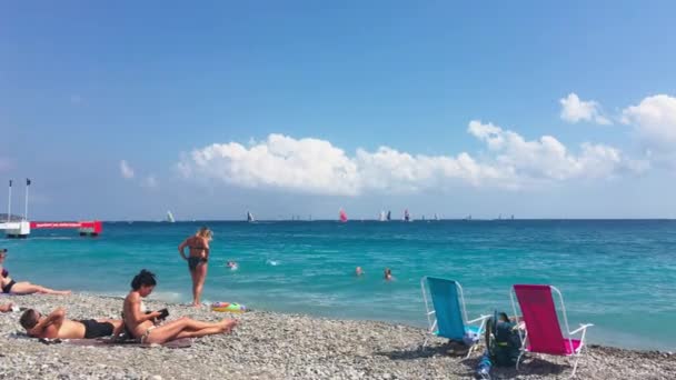 フランス,ニース, 21 7月2018:晴れた日には、メインビーチで多くの人々,ターコイズブルーの水,太陽から傘,地元の魅力-アングライスのプロムナード — ストック動画
