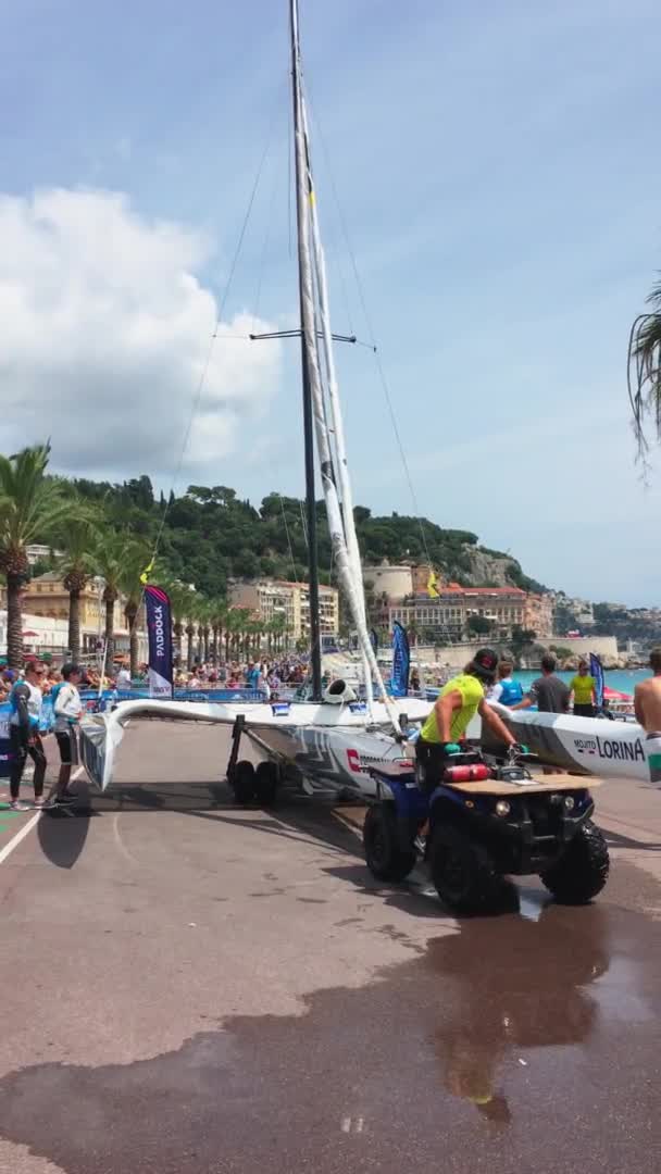 France, Nice, 22 juillet 2018 : Des images verticales de l'équipe sportive du catamaran à voile préparent son véhicule nautique et l'abaissent à l'eau, remblai principal Promenade des Anglais — Video