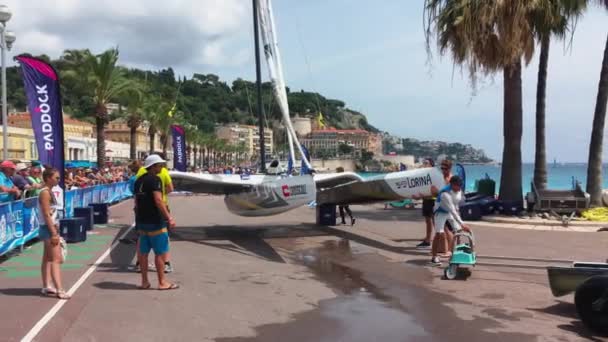 Francia, Niza, 22 de julio de 2018: El equipo deportivo del catamarán de vela prepara su vehículo acuático y lo baja al agua, terraplén principal Promenade des Anglais — Vídeo de stock