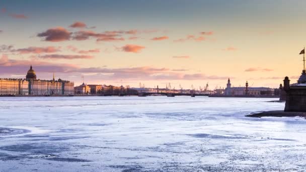 Rusya, Saint-Petersburg, gün batımında Neva Nehri 'nin su alanındaki zaman kaybı, Kış Sarayı, Saray Köprüsü, St. Isaac Katedrali' nin kubbesi, pembe bulutlar, donmuş nehir. — Stok video