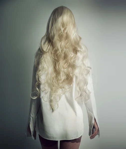 Meisje met witte haren in een wit overhemd staat met zijn rug — Stockfoto