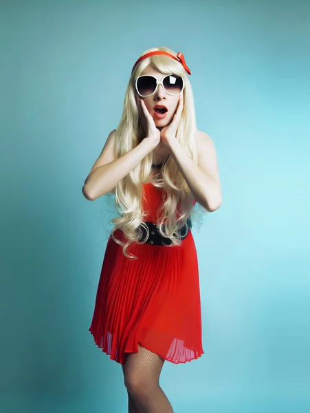 La chica en un vestido rojo sobre un fondo azul — Foto de Stock