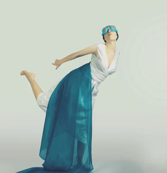 Flicka i en vit klänning och blå tyg skildrar en trollslända — Stockfoto