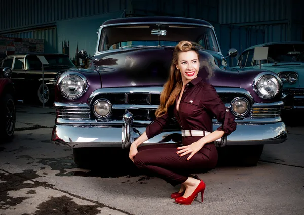 Chica en pin-up sobre un fondo de coches retro. aparcamiento —  Fotos de Stock