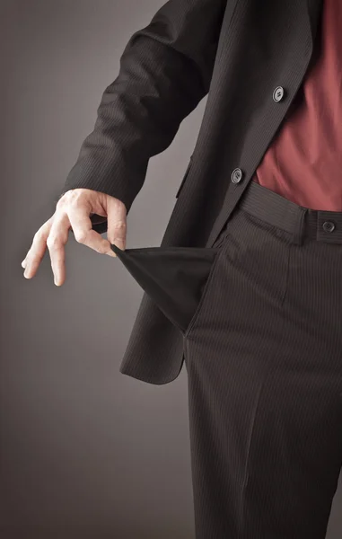 Poor businessman turning his empty pocket inside out to show his broke and out of money. — Stock Photo, Image