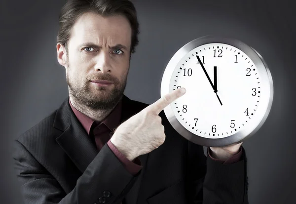 Cuarenta años de edad estricto exigente jefe con un dedo en el dedo en un reloj - indica una hora límite — Foto de Stock