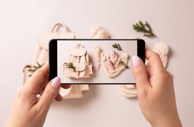 Kadın akıllı telefonuyla kış modası aksesuarlarının fotoğrafını çekiyor. Sosyal medya için Noel hediyeleri yakalayan blogcu, etkili ya da stilist.