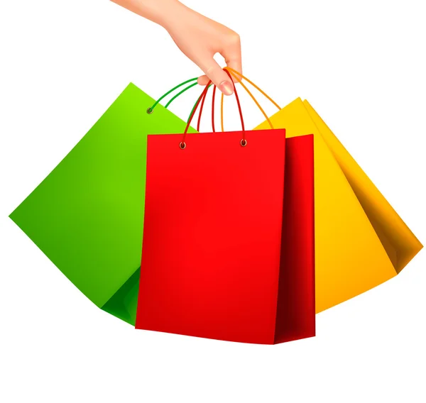 Mano femenina sosteniendo bolsas de compras coloridas. Ilustración vectorial . — Vector de stock