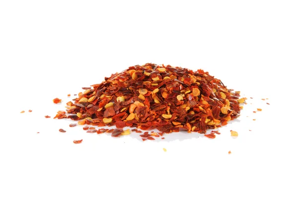 Högen av röd paprika flingor på en vit bakgrund — Stockfoto