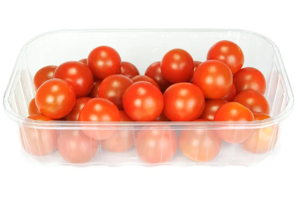Tomates cereja em um recipiente de plástico no fundo branco — Fotografia de Stock