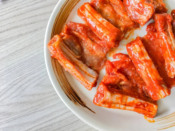 Bir sürü çiğ pirzola. Beyaz tabakta domuz eti.