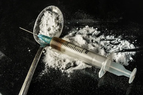 Drugsspuit en gekookte heroïne op lepel — Stockfoto