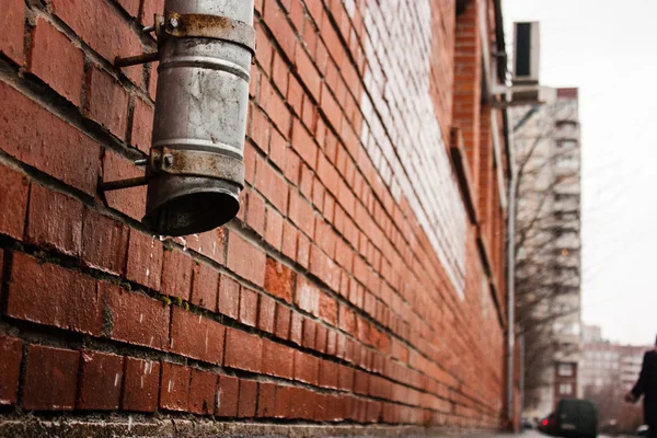 Tube noir sur un mur de la maison de briques (égoutter l'eau ) — Photo