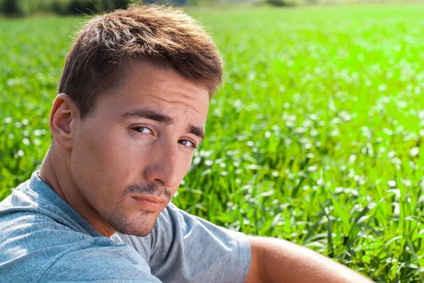 Retrato de um jovem bonito em um parque — Fotografia de Stock