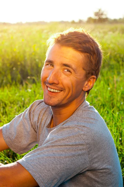 Portrait of a handsome young man in a park — Stock Photo, Image