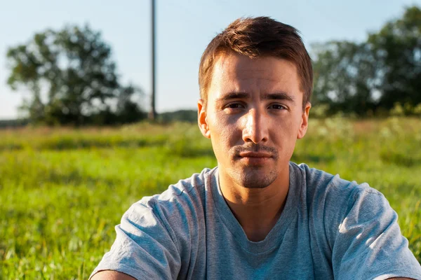 Retrato de um jovem bonito em um parque — Fotografia de Stock