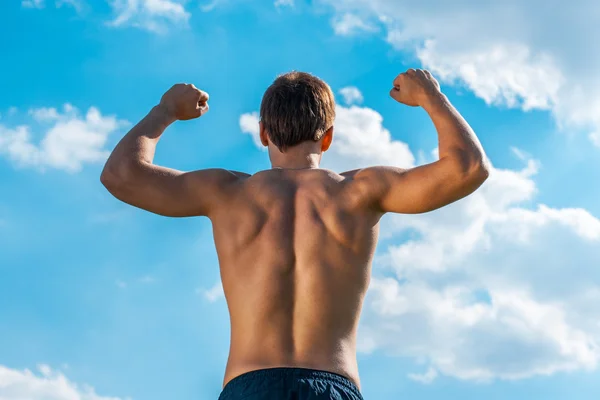 The won person with the raised hands against the sky. view from a back — Stock Photo, Image