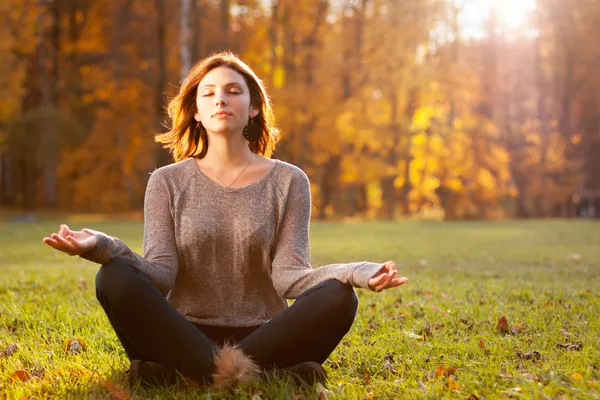 Hermosa joven meditando en el parque de otoño — Foto de Stock